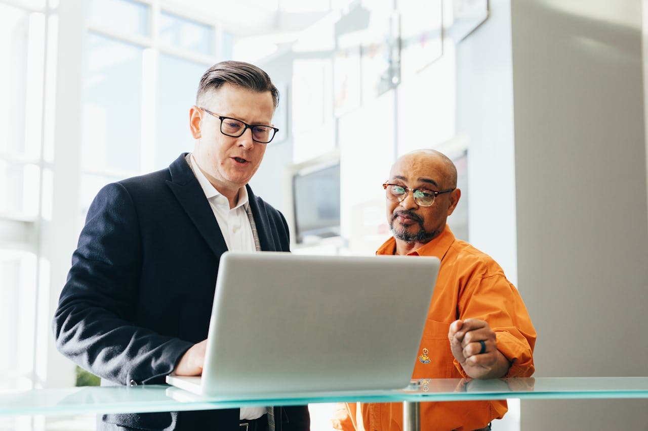 Sales man showing something on his laptop.